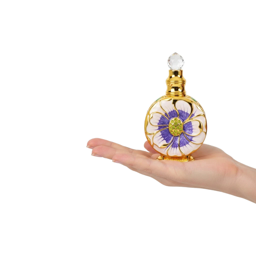 Hand holding a Layali for Women Perfume Oil perfume bottle with floral design on a white background