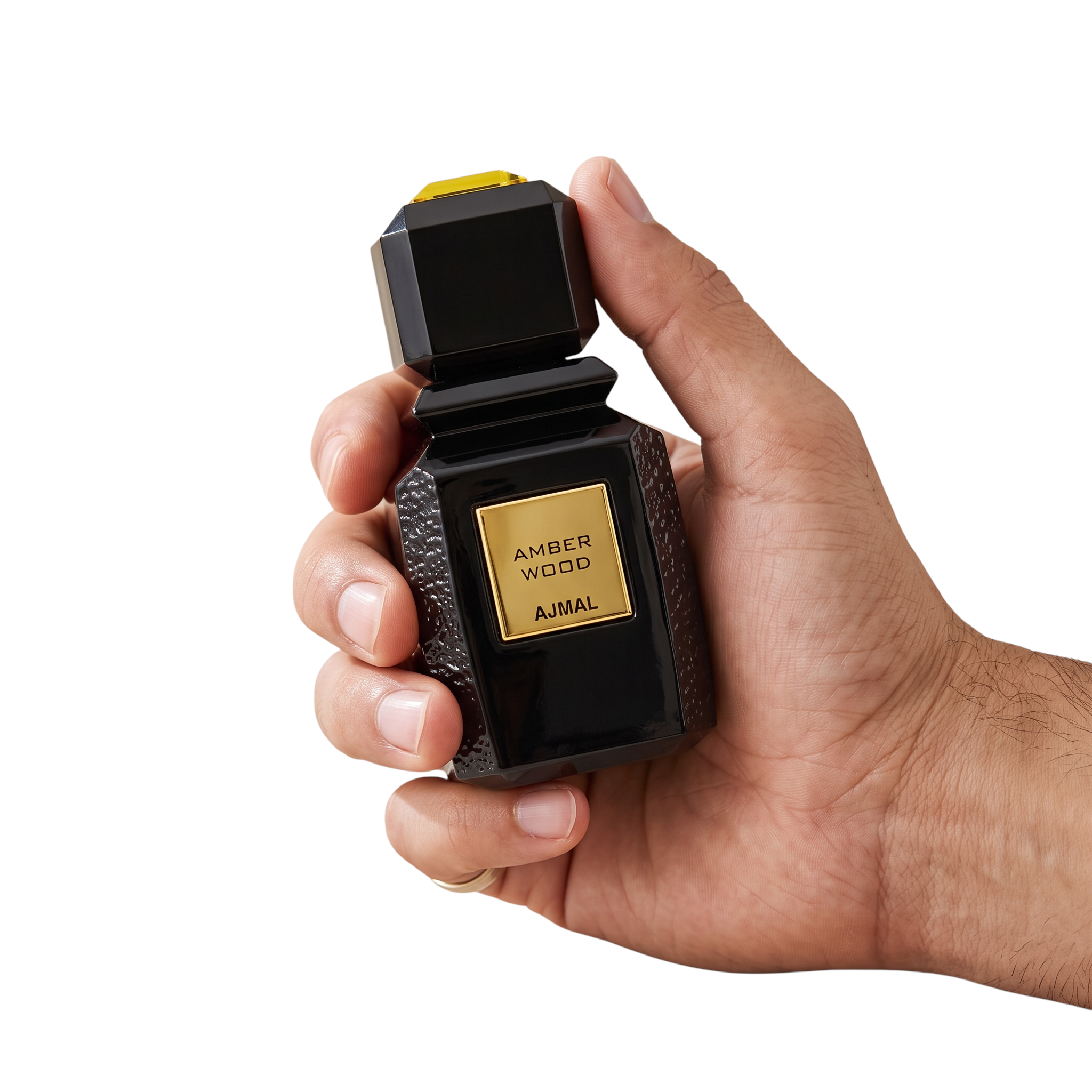 Palette 21 Ajmal Amber Wood unisex eau de parfum in a black textured bottle with gold accents held in a hand