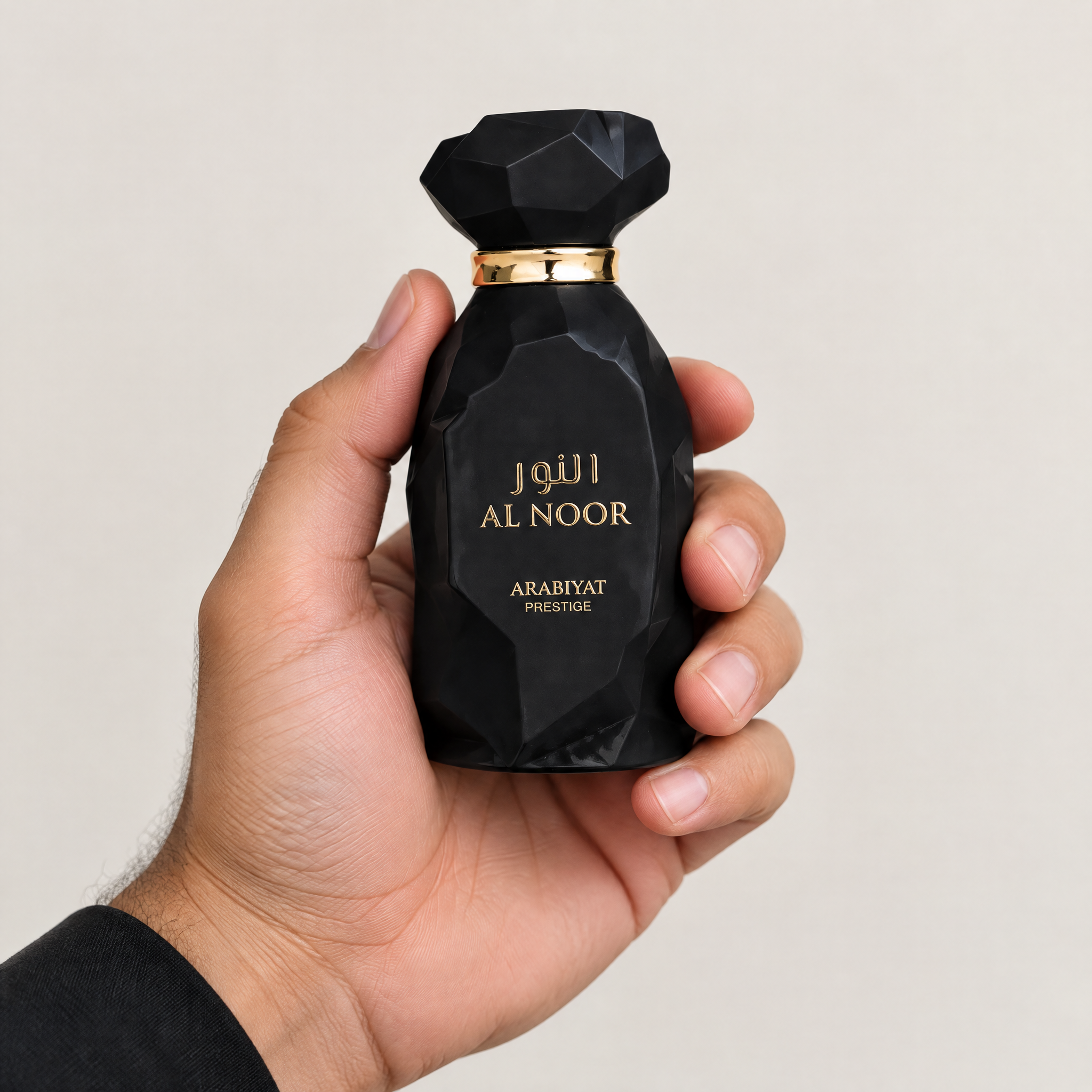Palette 21 ARABIYAT PRESTIGE Al Noor unisex Eau de Parfum in a multifaceted black bottle with gold accents held in hand