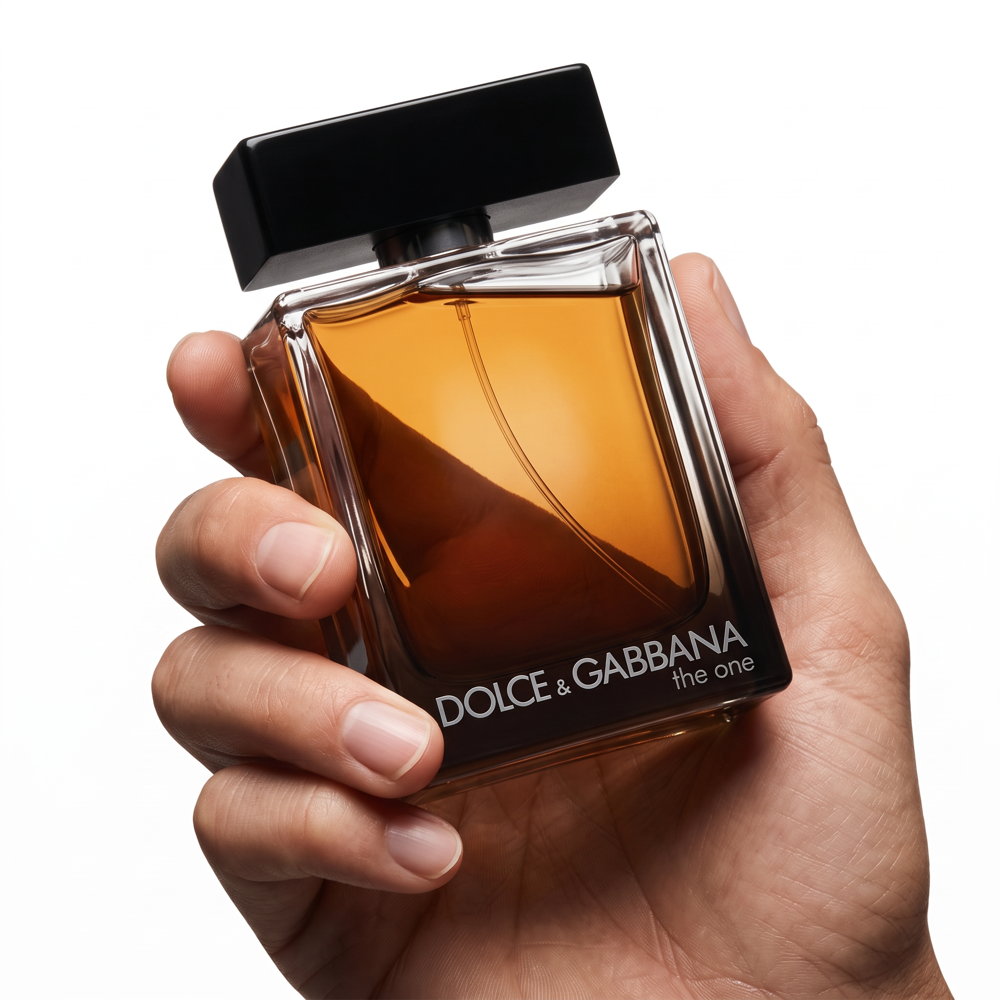 Palette 21 Dolce & Gabbana The One Eau de Parfum for men in a glass bottle held in a hand against a white background.