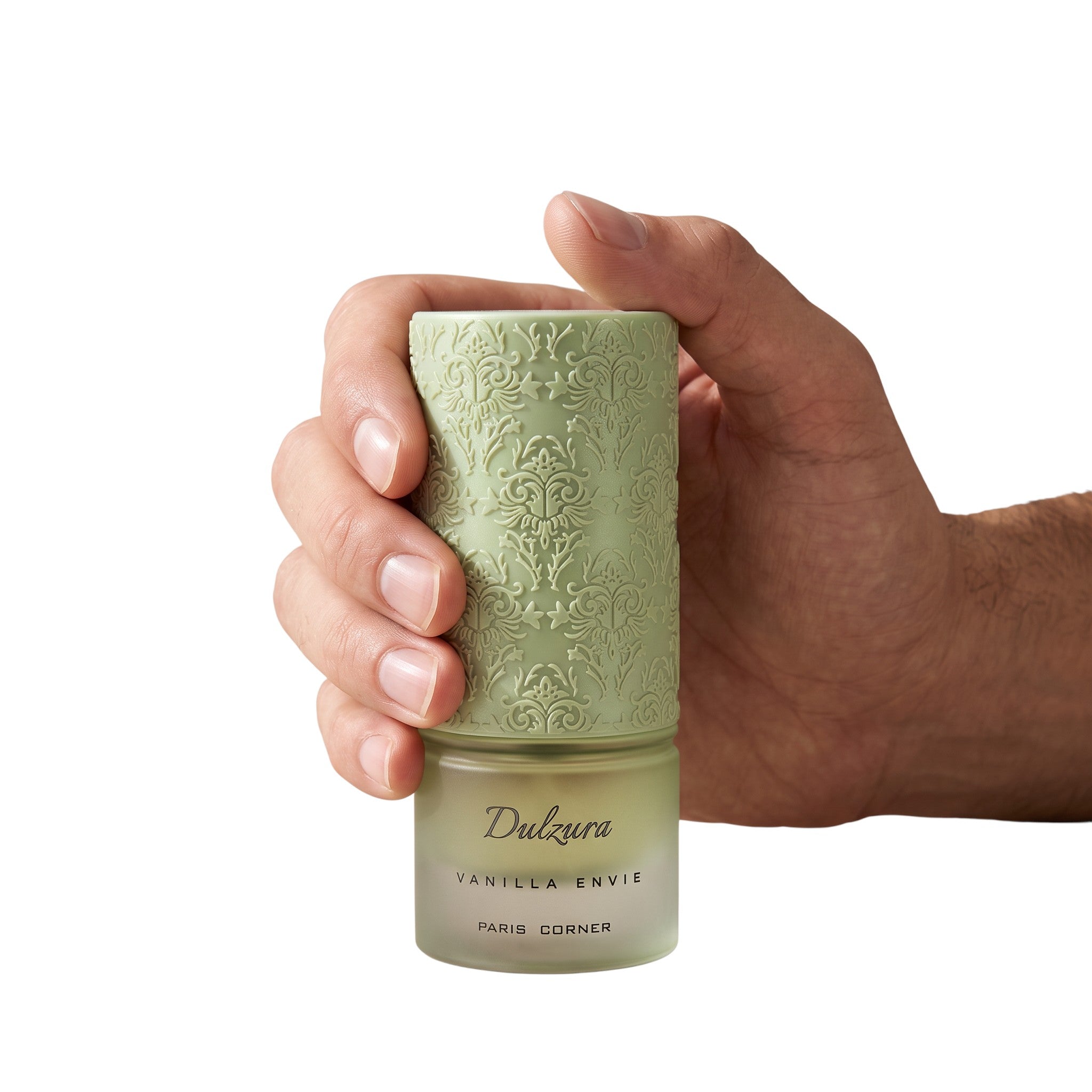 Palette 21 Paris Corner Dulzura Vanilla Envie perfume bottle with an intricate sage green embossed cap held in a hand.
