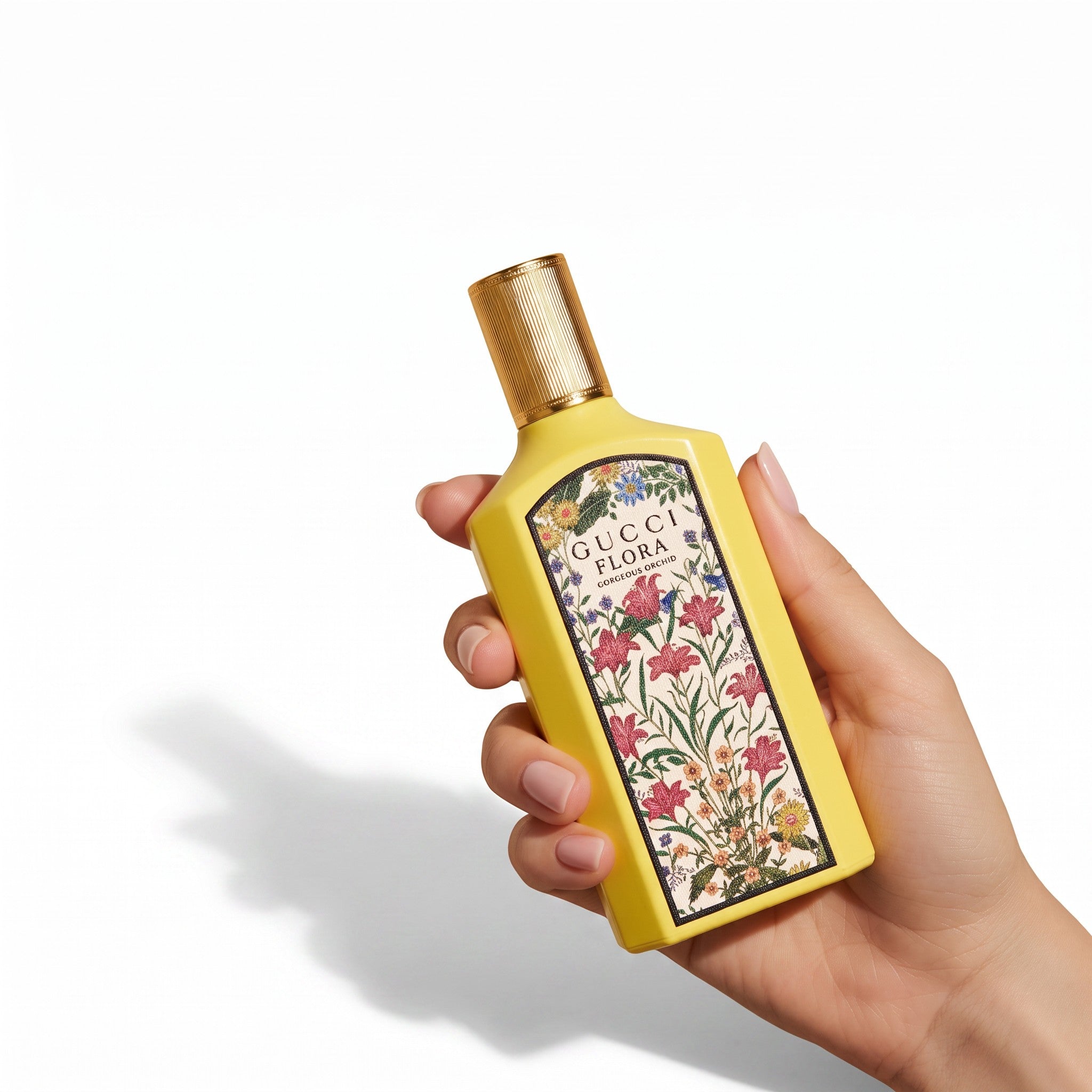 Palette 21 Gucci Flora Gorgeous Orchid perfume bottle held in hand, featuring a yellow bottle with floral print.