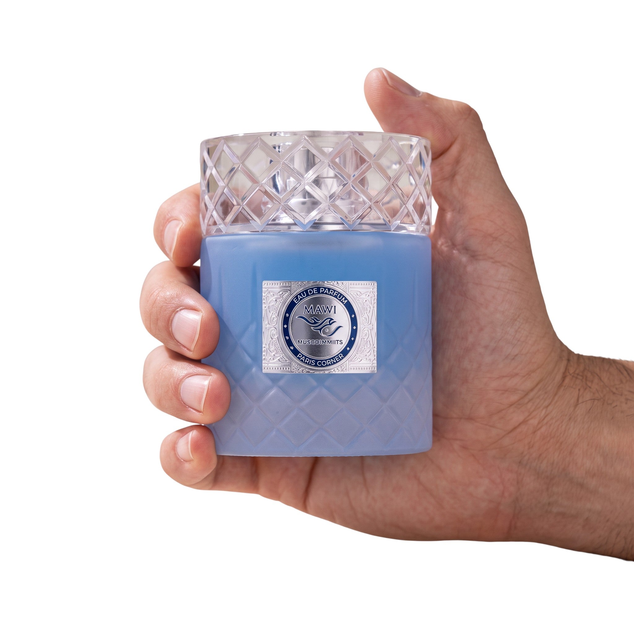 Palette 21 Paris Corner Mawj Eau De Parfum in a textured blue glass bottle with a crystal cap held in a hand