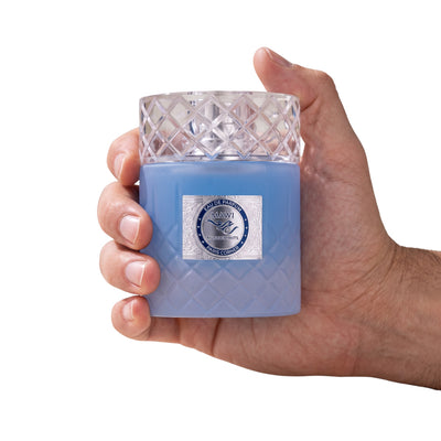 Palette 21 Paris Corner Mawj Eau De Parfum in a textured blue glass bottle with a crystal cap held in a hand