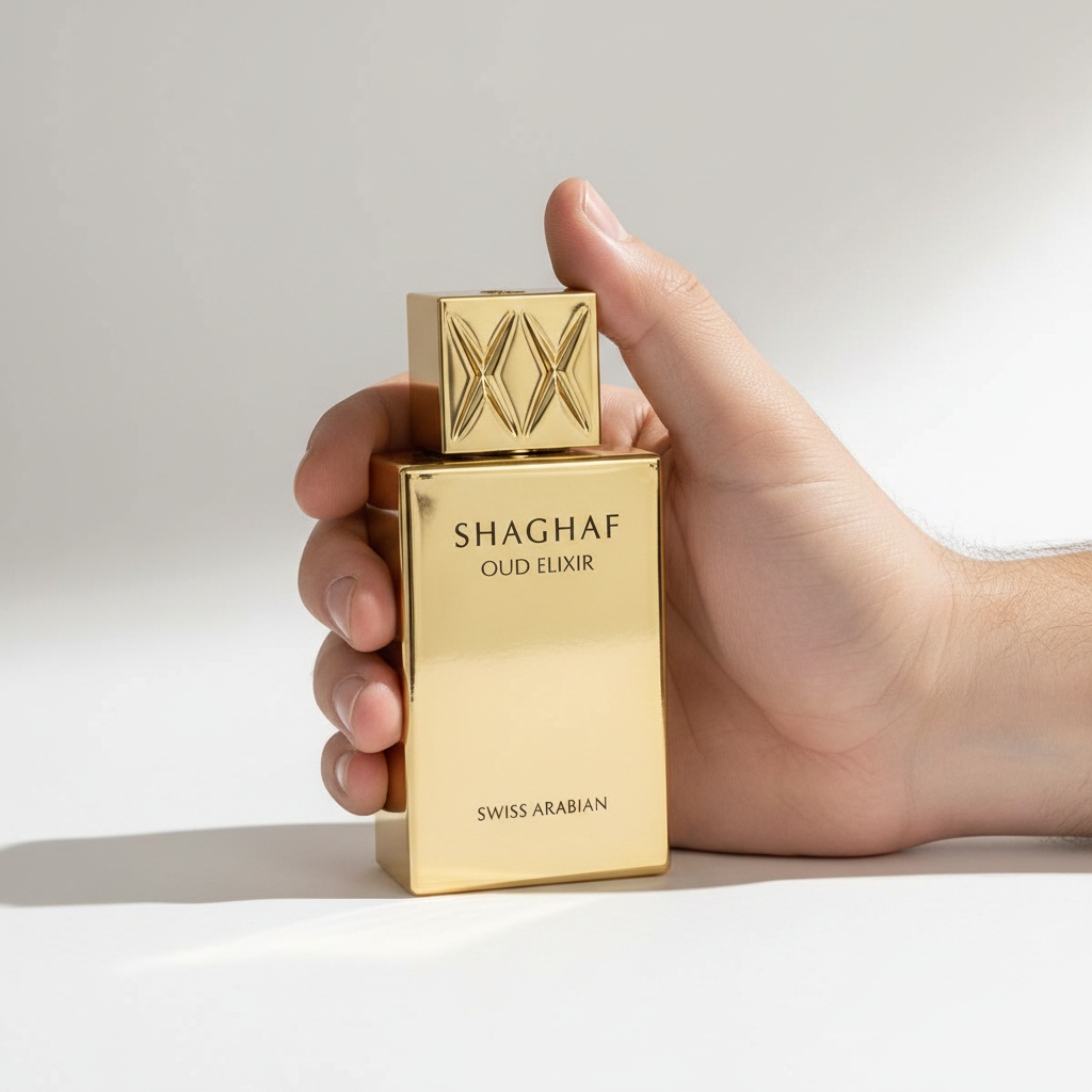 Palette 21 SWISS ARABIAN Shaghaf Oud Elixir perfume in a polished gold bottle held in a hand against a white background