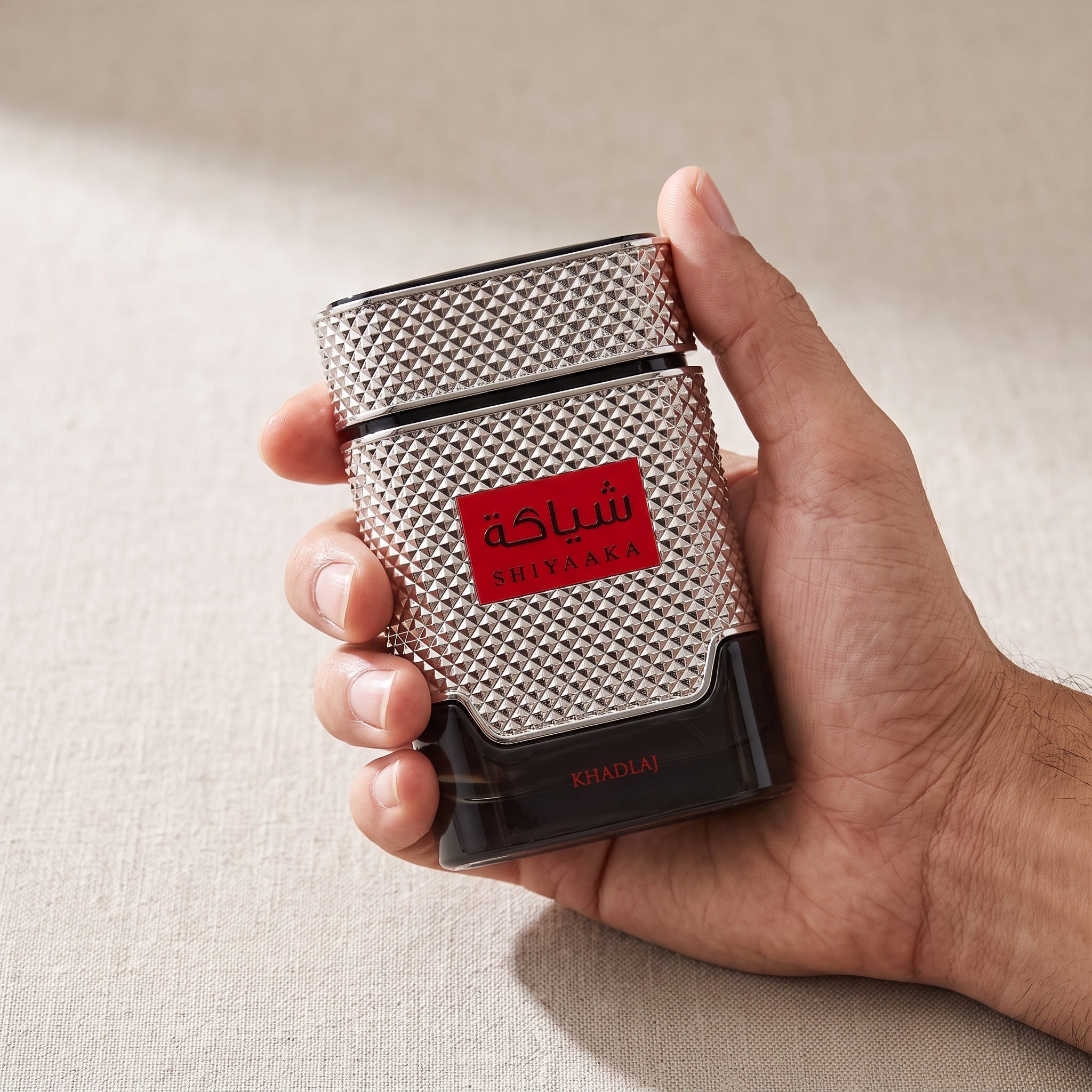 Palette 21 Shiyaaka for Men by Khadlaj Perfumes in a textured silver and black bottle held in a hand