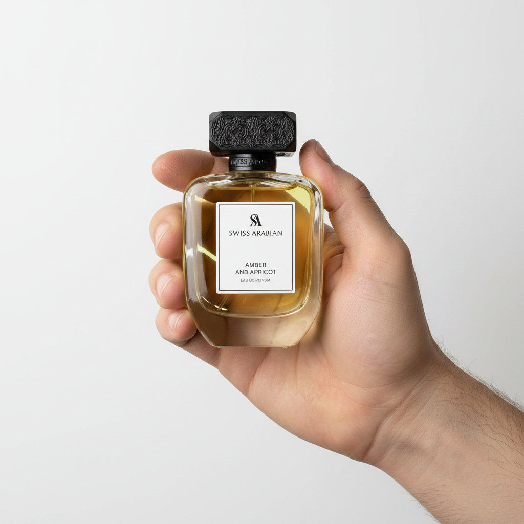 Palette 21 Swiss Arabian Amber and Apricot Eau de Parfum in a glass bottle with a textured black cap held in a hand.