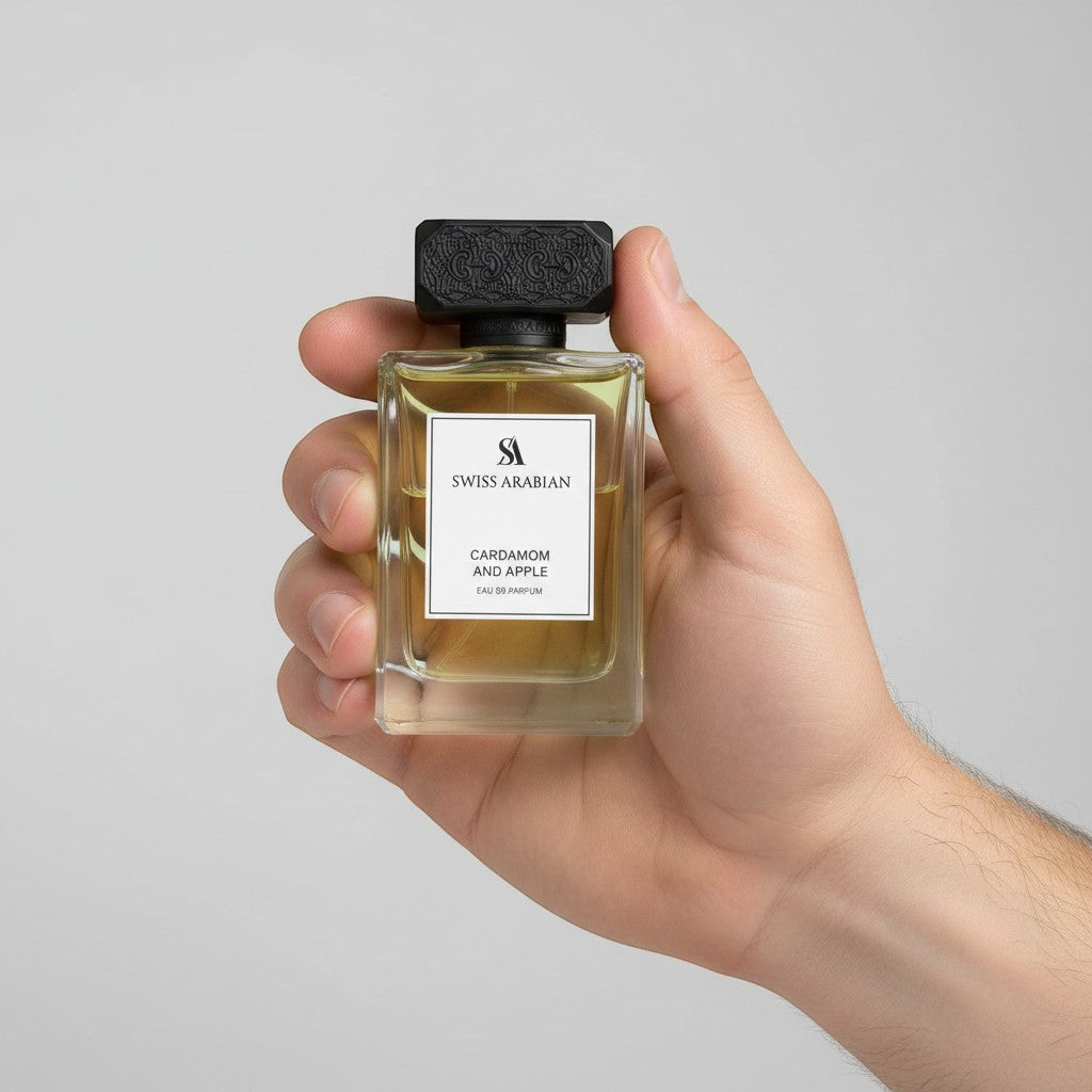 Palette 21 Swiss Arabian Cardamom and Apple Eau de Parfum in a clear glass bottle with a black cap held in a hand.