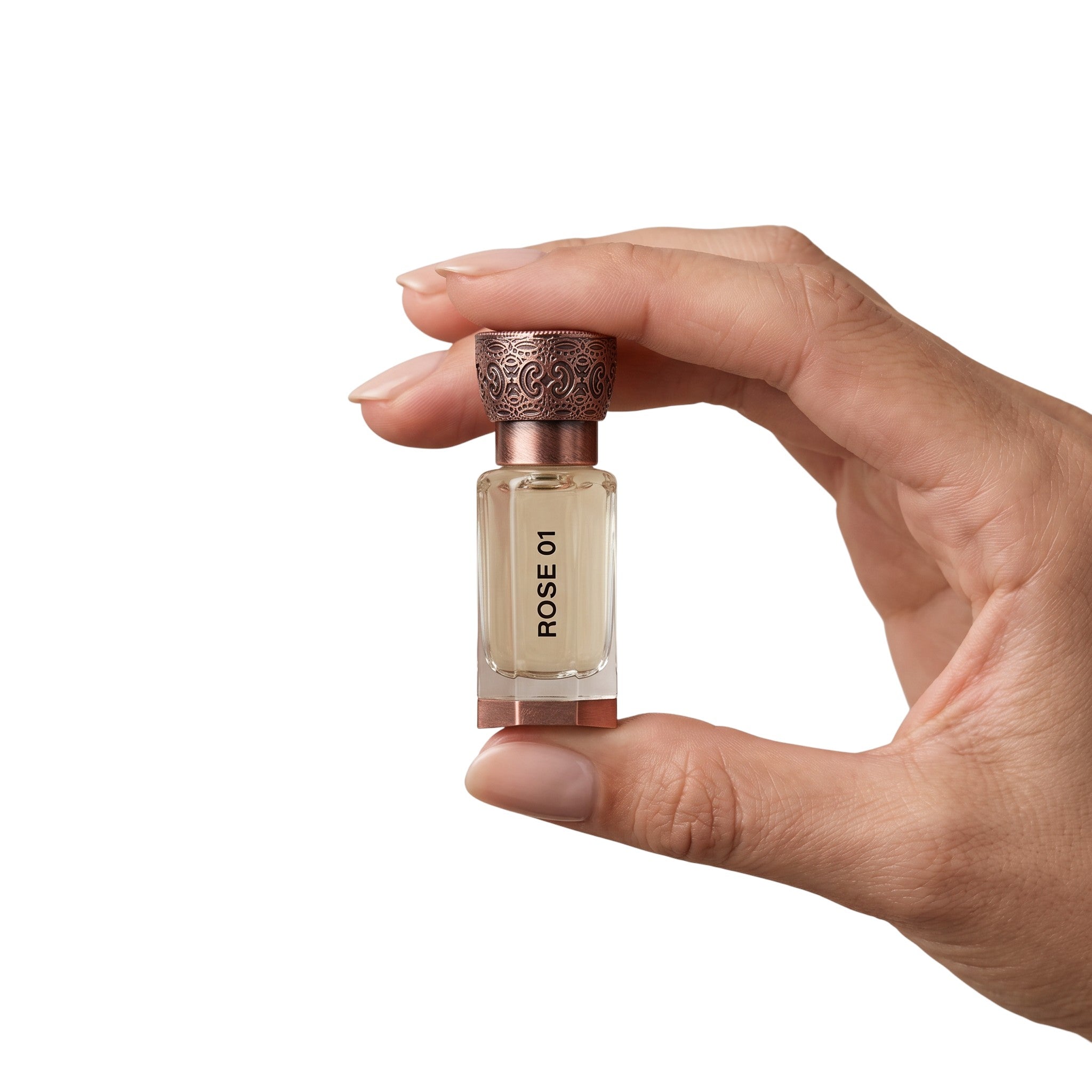 Hand holding the travel size 12ml Swiss Arabian Rose 01 alcohol-free rose attar bottle